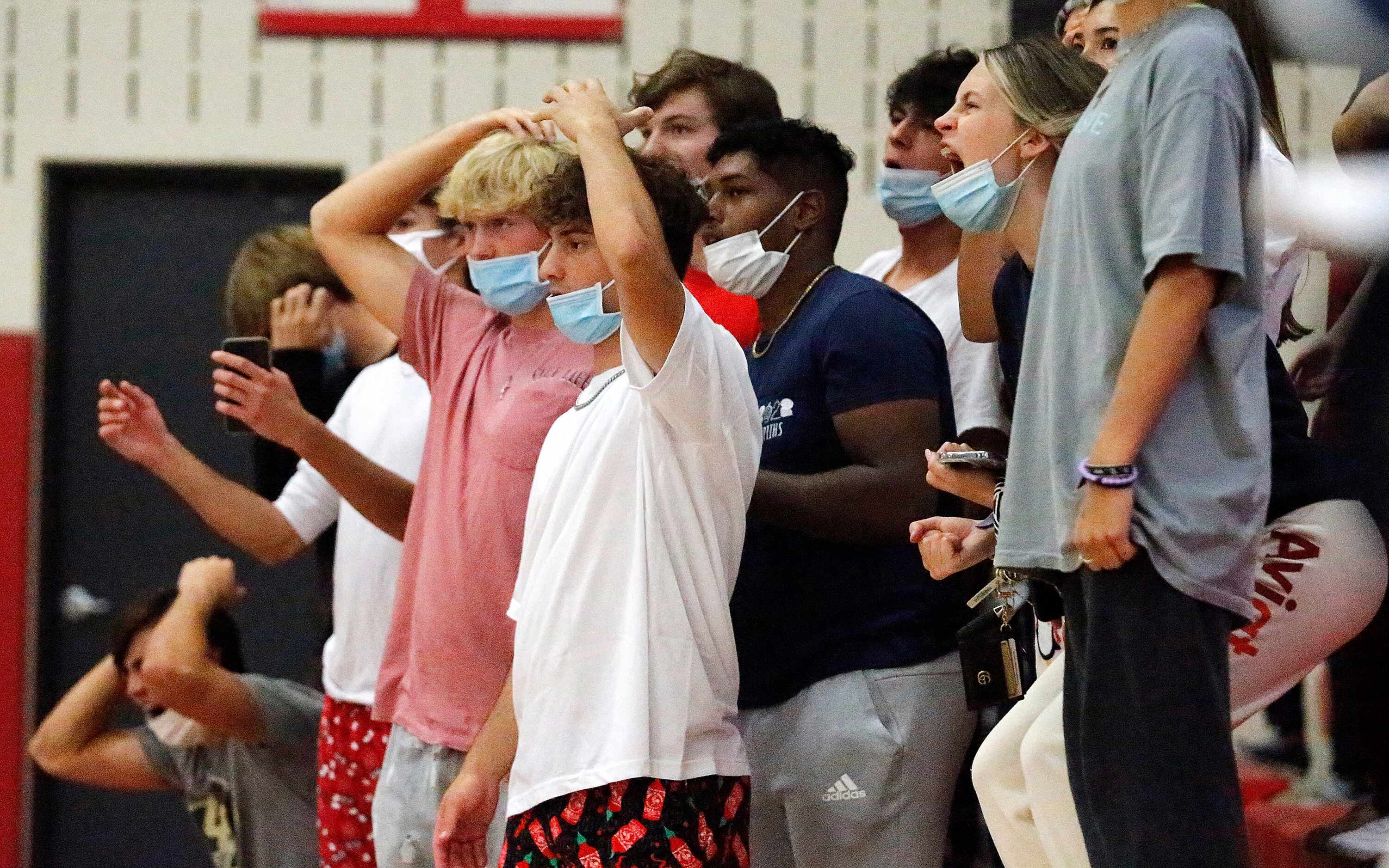 The John Paul II High School student section reacts to the loss of the lead in game one as...