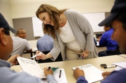  Richland College instructor Elke Brautigam checks the writing by Plano Parks and Recreation...