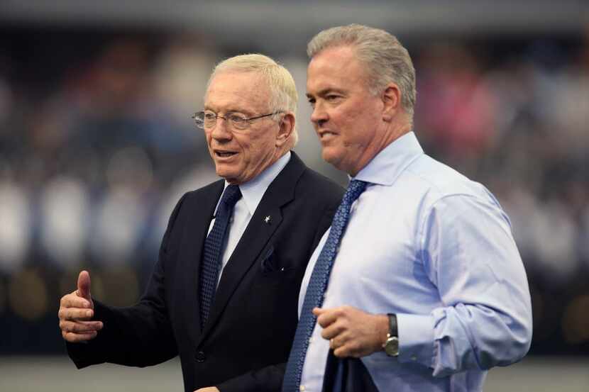 Sep 22, 2013; Arlington, TX, USA; Dallas Cowboys owner Jerry Jones talks with son executive...