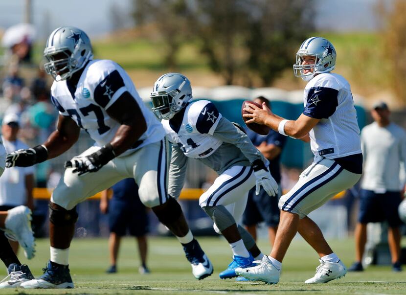 Dallas Cowboys quarterback Tony Romo (9) drops back to pass as he receives up front help by...