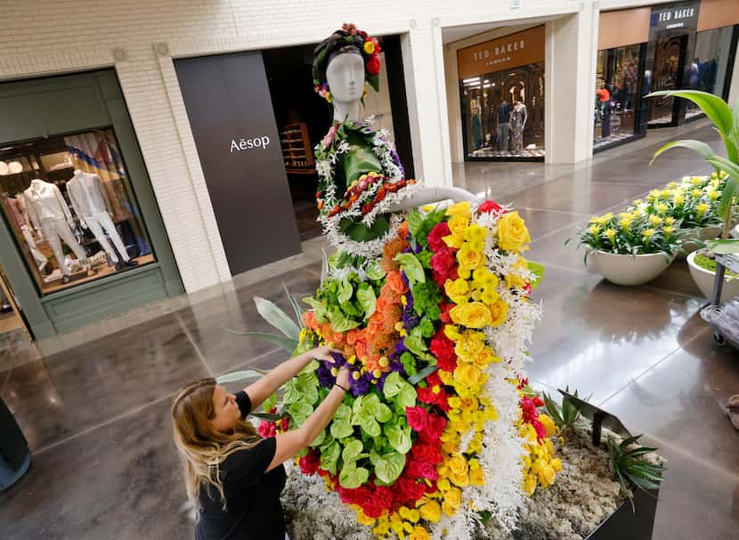 Julia Kelly of Concepto creates a flower dress for a mannequin with other team members,...