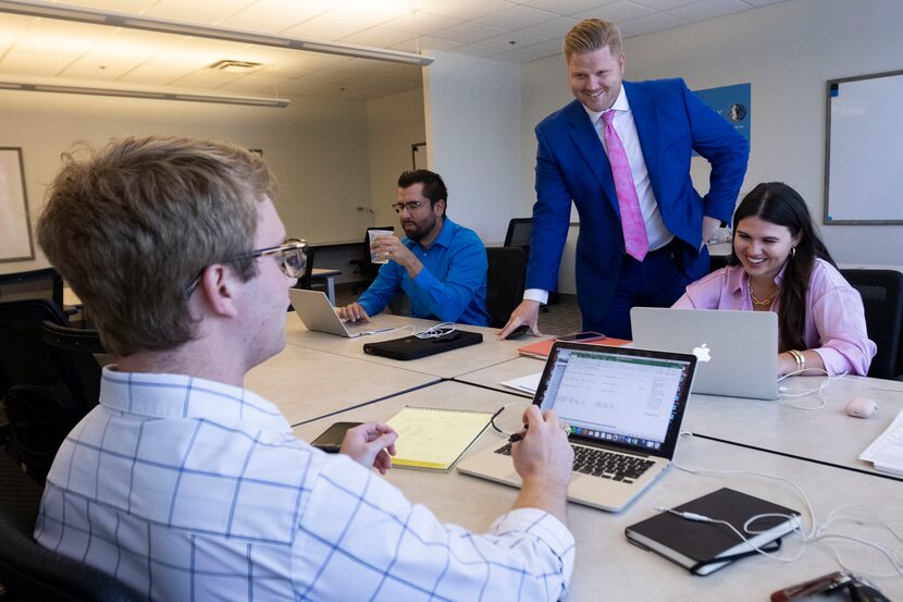 The commercial real estate team chats at the Rogers Healy and Associates office in Dallas. 