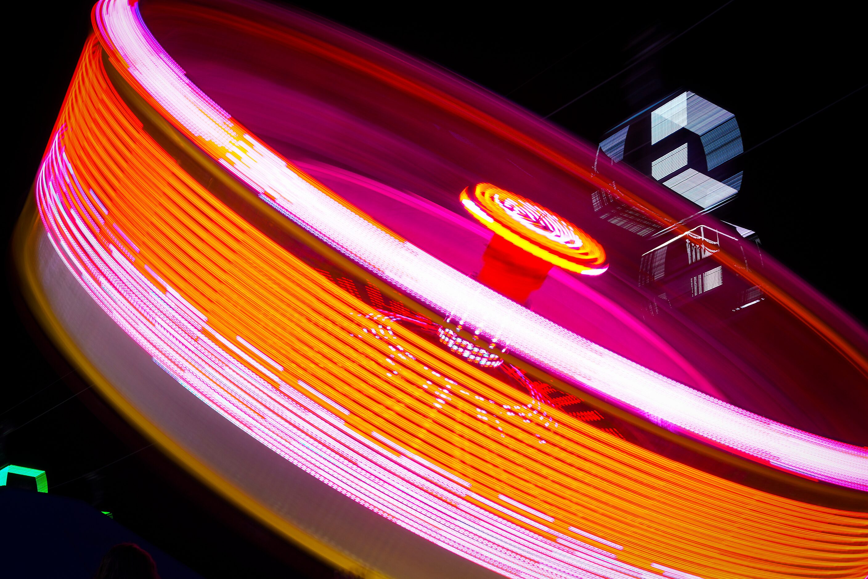 Cars on the Texas Skyway are seen over the spinning Zero Gravity ride on the midway in a...