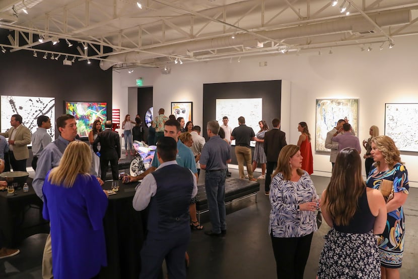 New York Life staffers sip wine and look at art at the Samuel Lynne Galleries in Dallas at a...