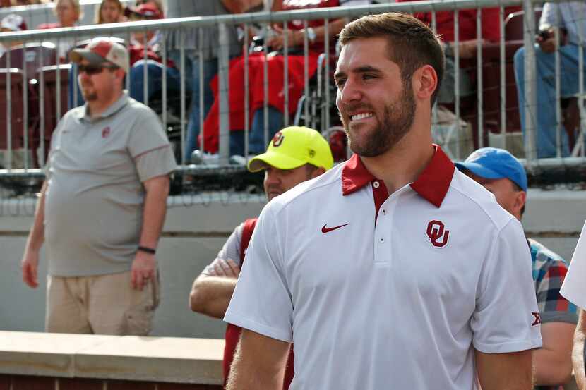 Former Oklahoma quarterback Trevor Knight watches from the sidelines before an NCAA college...
