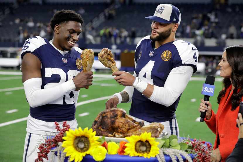 Dallas Cowboys cornerback DaRon Bland (26) and quarterback Dak Prescott (4) bump turkey legs...