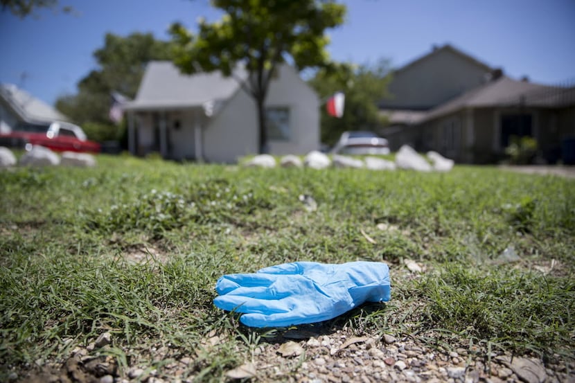 A surgical glove lies near the sidewalk in the 400 block of S. Kramer Drive where a police...