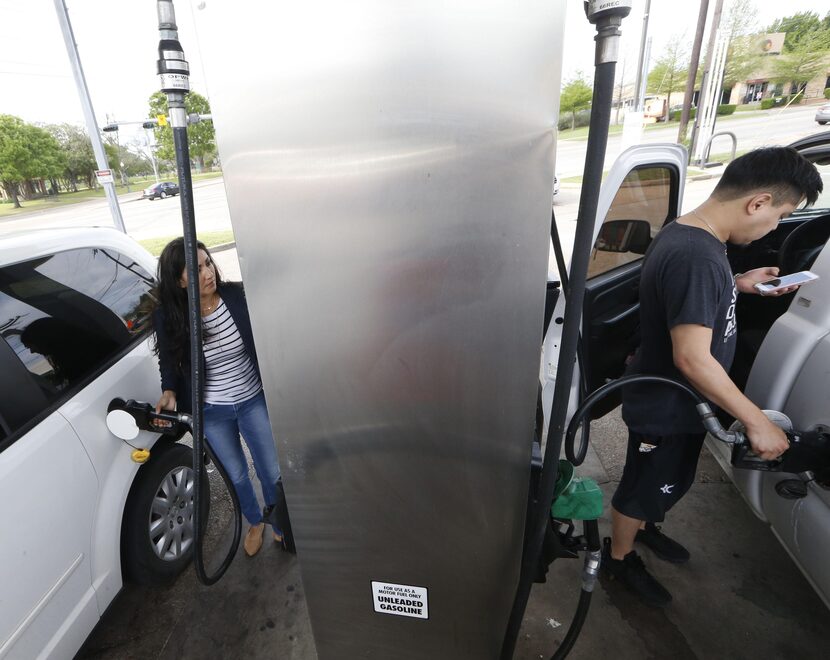 Amelia Banda (izq.) y Andrew Rivas ponen gasolina en una estación en N. Zang Boulevard y...