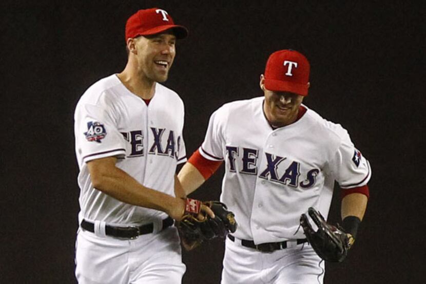 Texas Rangers center fielder Craig Gentry (23) congratulates left fielder David Murphy (7)...