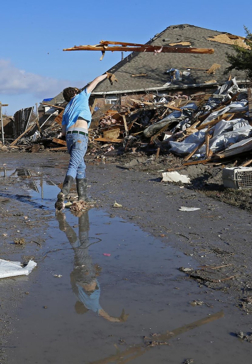 Volunteer Marshall Sullivan,  18, of Wylie throws scattered debris in the Pebble Beach Drive...