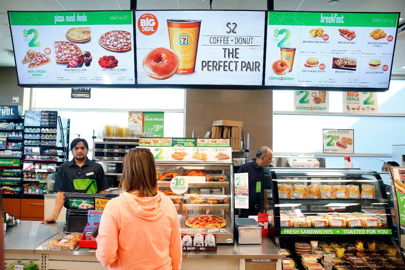 7-Eleven uses a new digital menu sign above the cash 
register in a convenience store...