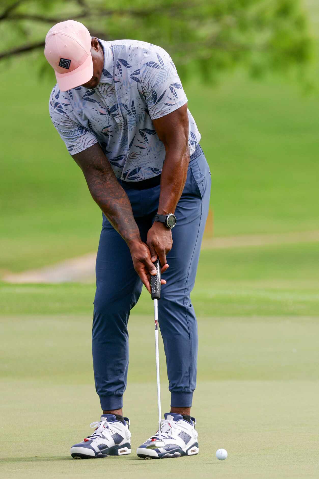 Former Dallas Cowboys player DeMarcus Ware putts on the 14th green during the first round of...