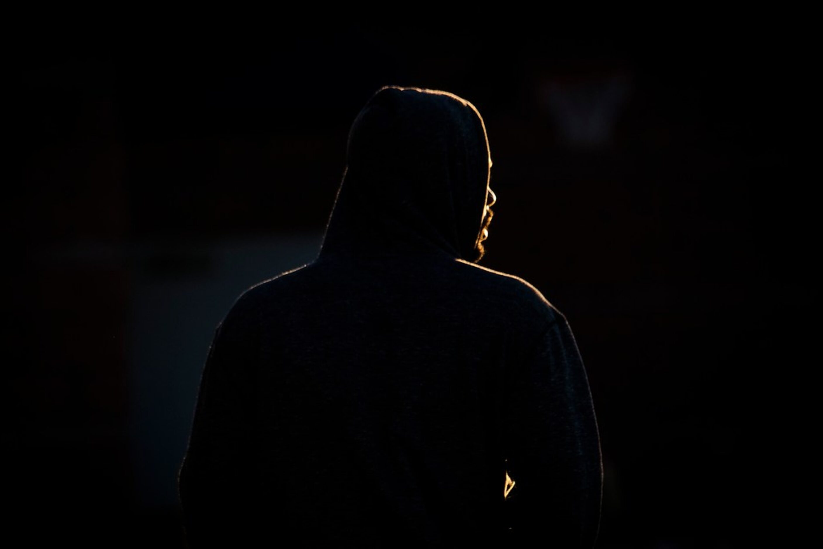 Texas Rangers pitcher Taylor Hearn is illuminated by the first rays of morning light as he...