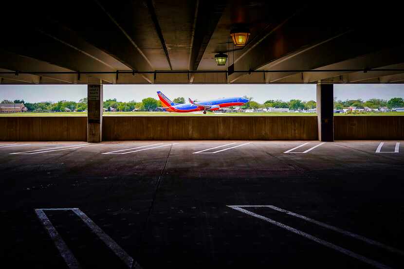 A Southwest Airlines 737 takes off past the second level of Garage A at Dallas Love Field,...