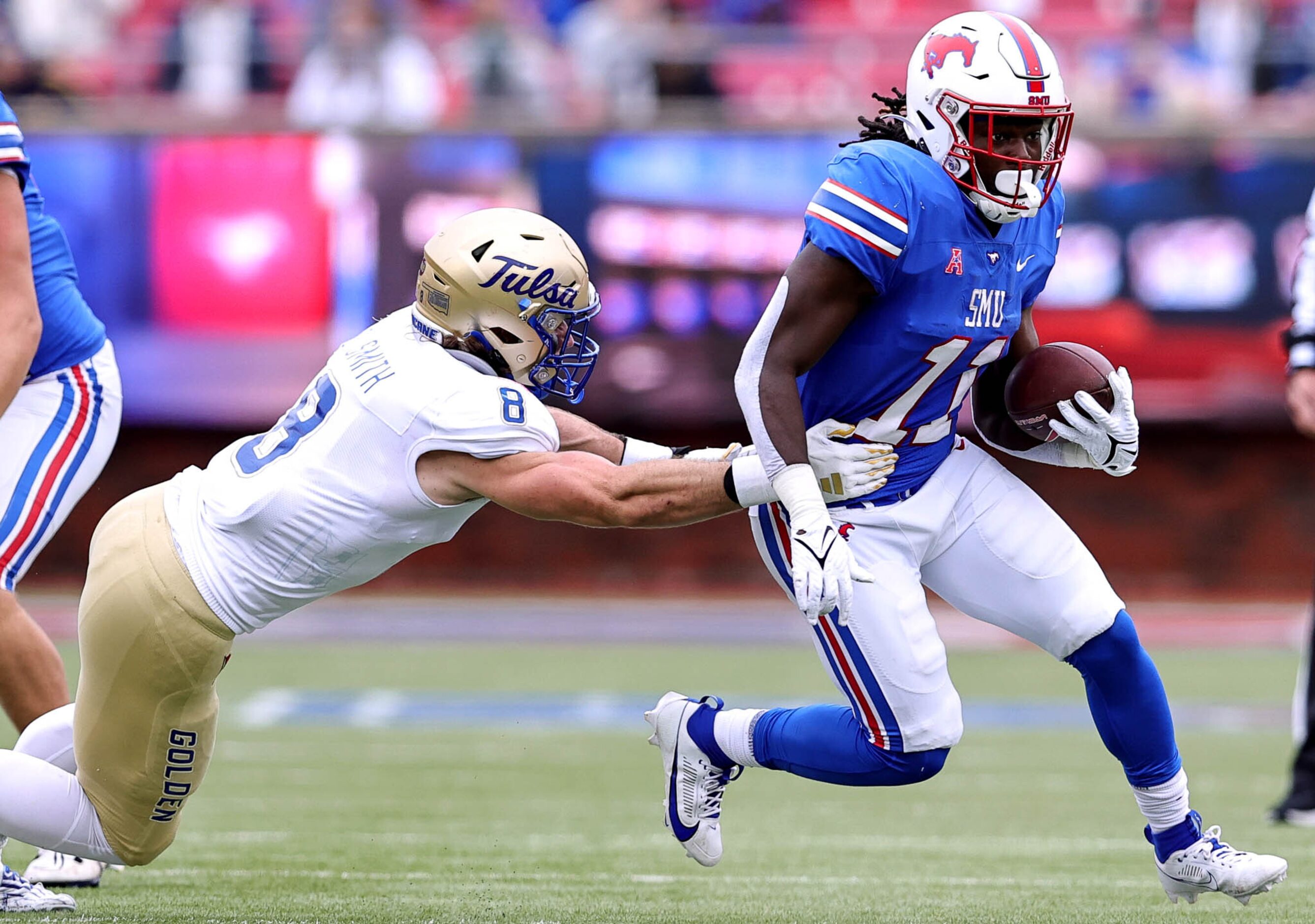 SMU running back LJ Johnson Jr (11) tries to get past Tulsa linebacker Coleton Smith (8) for...