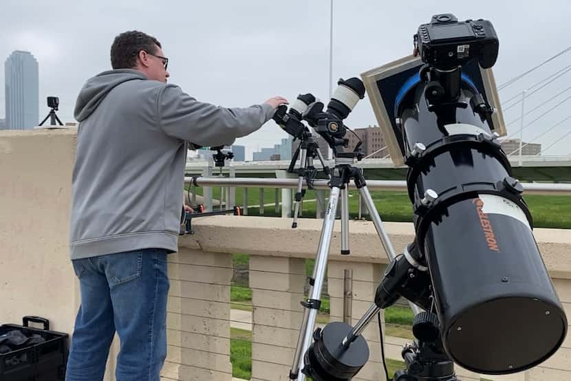 David Sim, of Carrollton, sets up camera equipment on the Ron Kirk Pedestrian Bridge on...