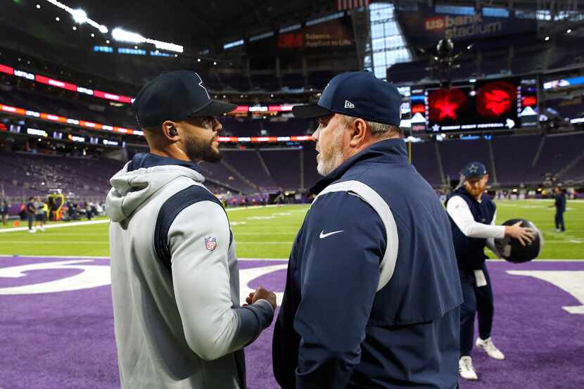 Dallas Cowboys head coach Mike McCarthy (right) visits with quarterback Dak Prescott as he...