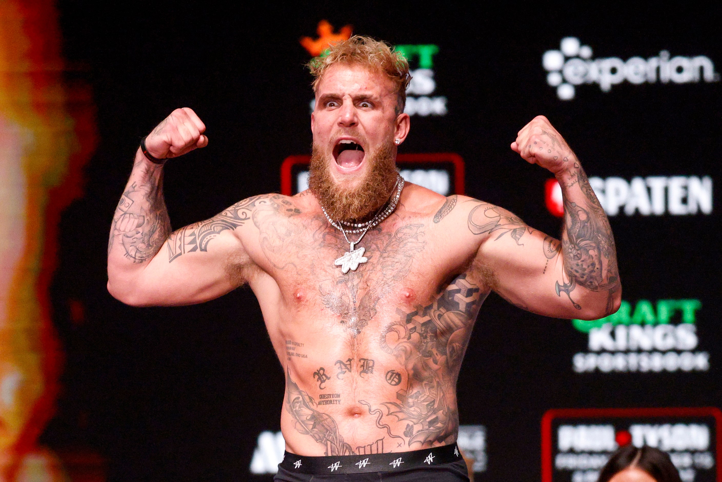 Jake Paul flexes as he stands on the scale during public weigh-ins ahead of his boxing match...