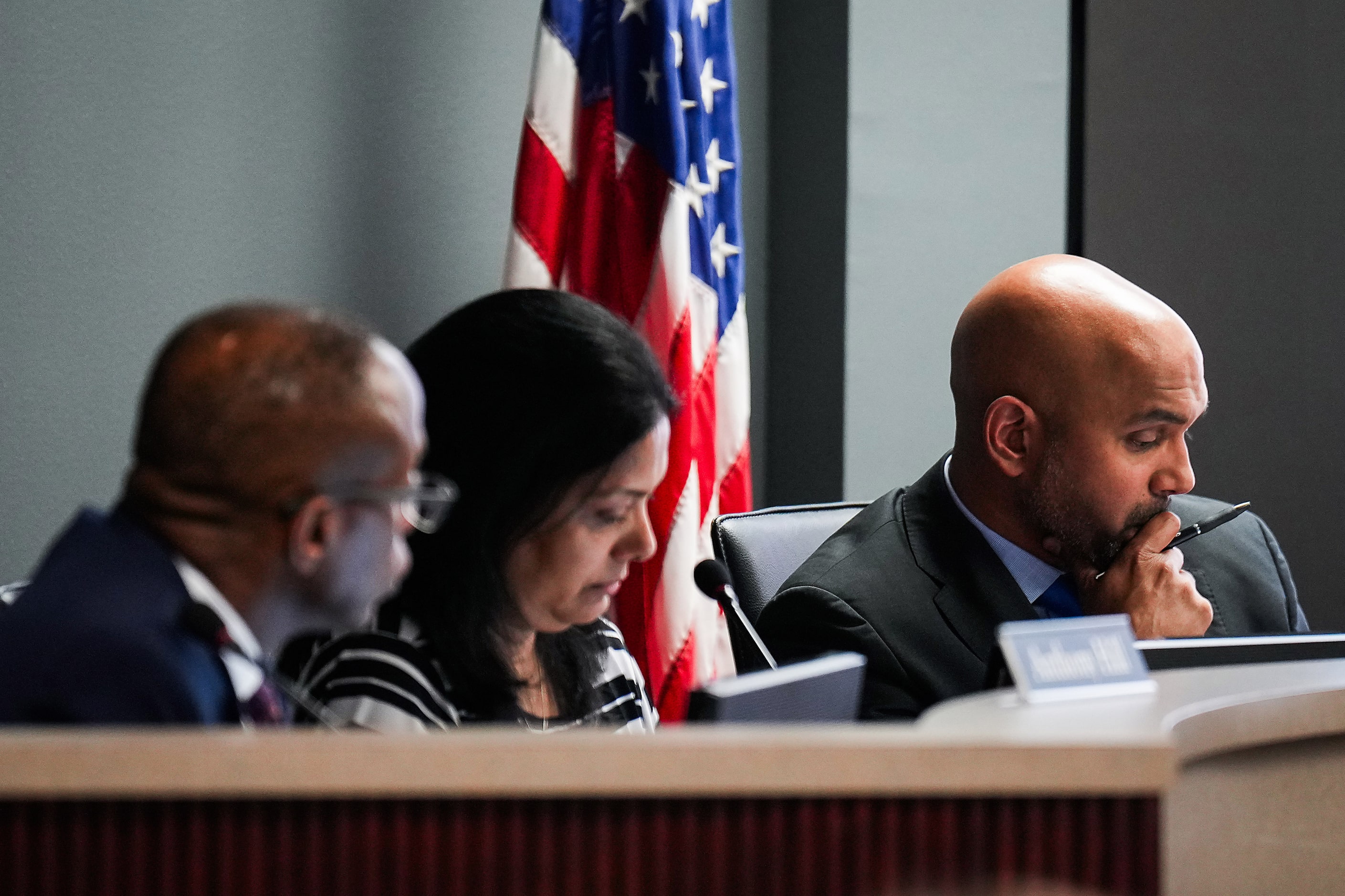 Coppell ISD school secretary Jobby Mathew (right) looks at a staff presentation alongside...