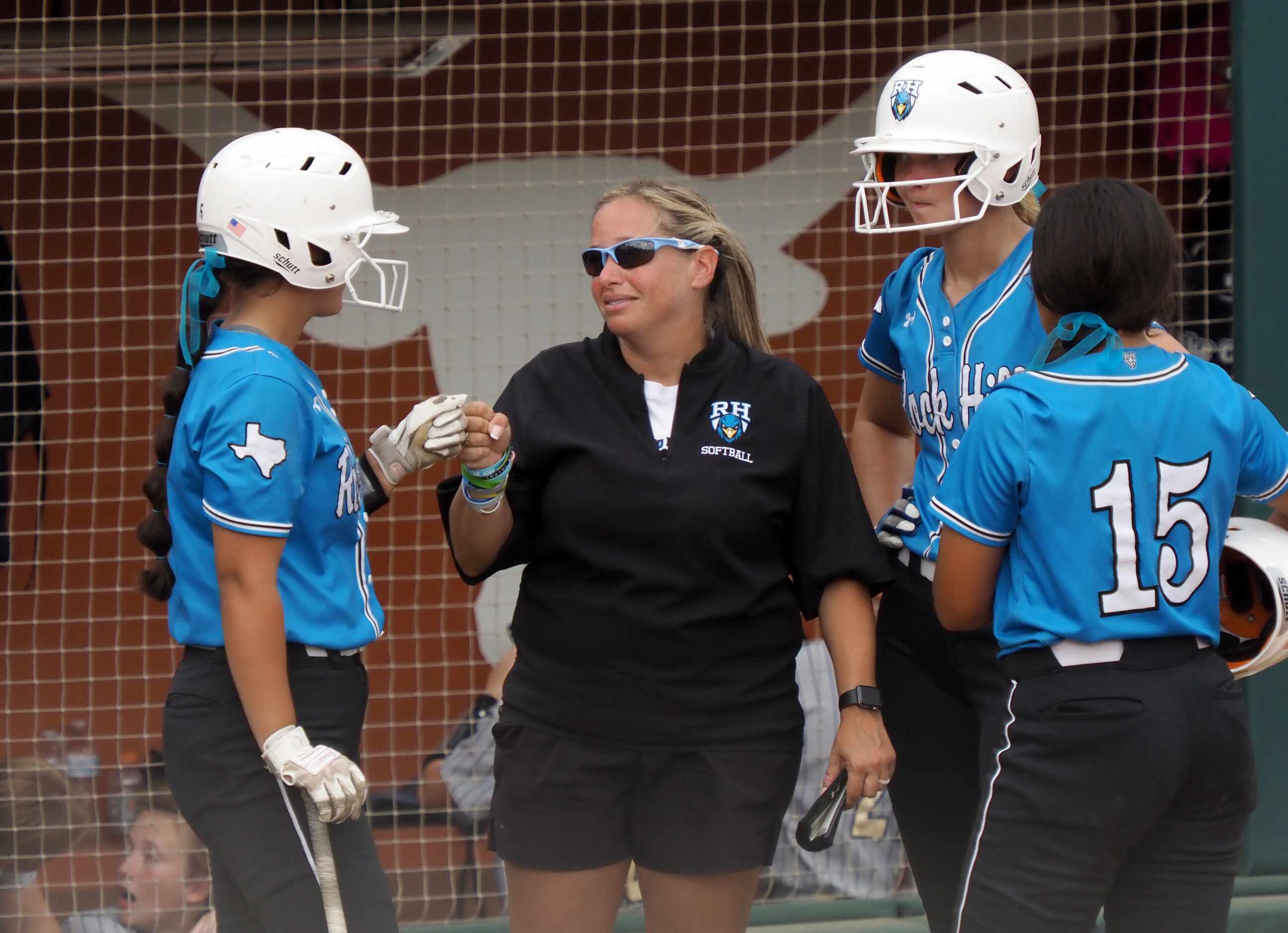 Prosper Rock Hill head coach Leigh Anne Budd (center) talks to her batter and baserunners...