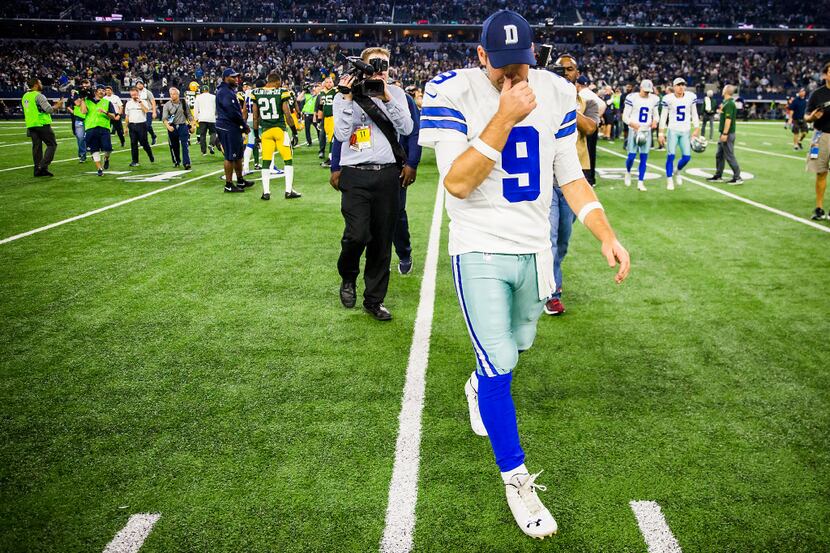 Dallas Cowboys quarterback Tony Romo walks off the field after the Green Bay Packers kicked...