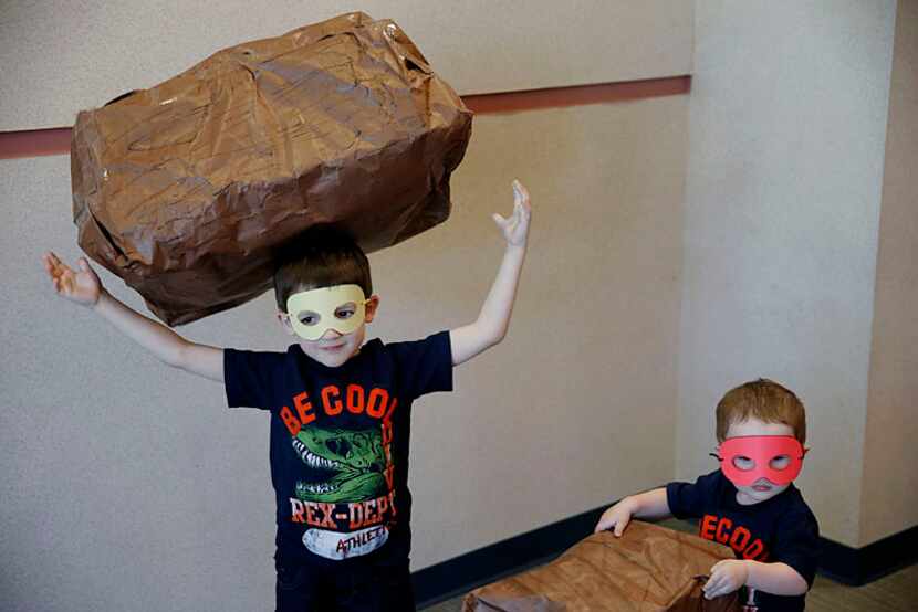  Two brothers from Plano play around with handmade boulders on an obstacle course during the...