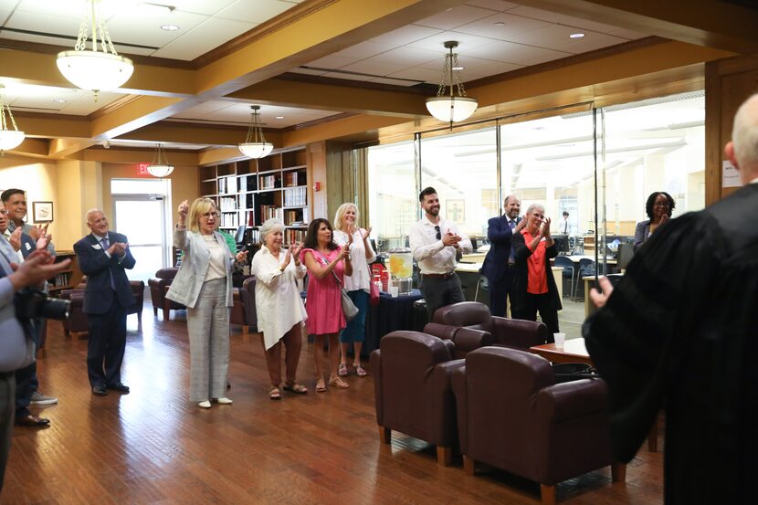 Family, friends and legal representatives of Brendan Higgins and Jacques DeLira cheer as...