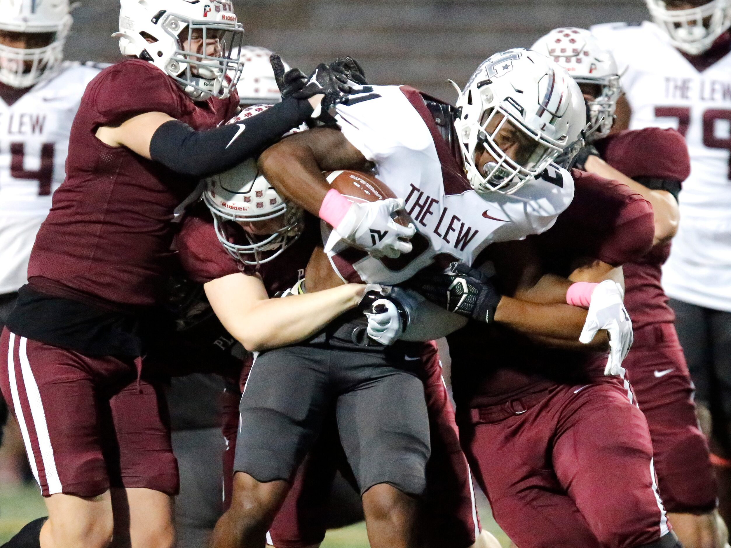 Lewisville High School running back Viron Ellison (21) is met by the Plano defensive line...