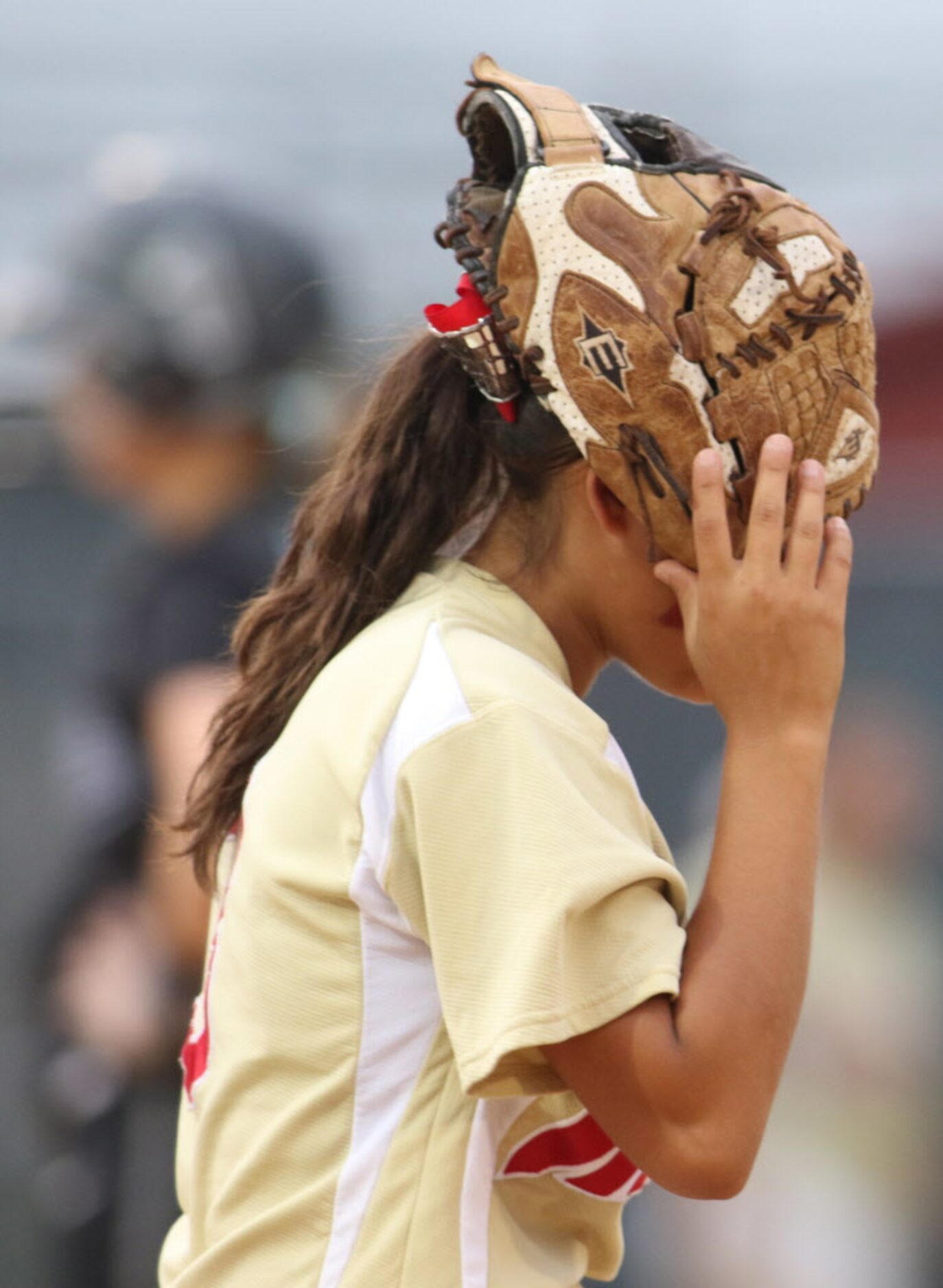 South Grand Prairie second baseman Jessica Gonzales (3) places her glove on her head in...