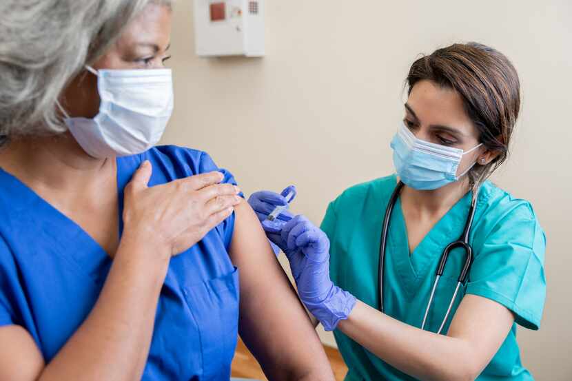 Una enfermera aplica la vacuna en el brazo de una persona.