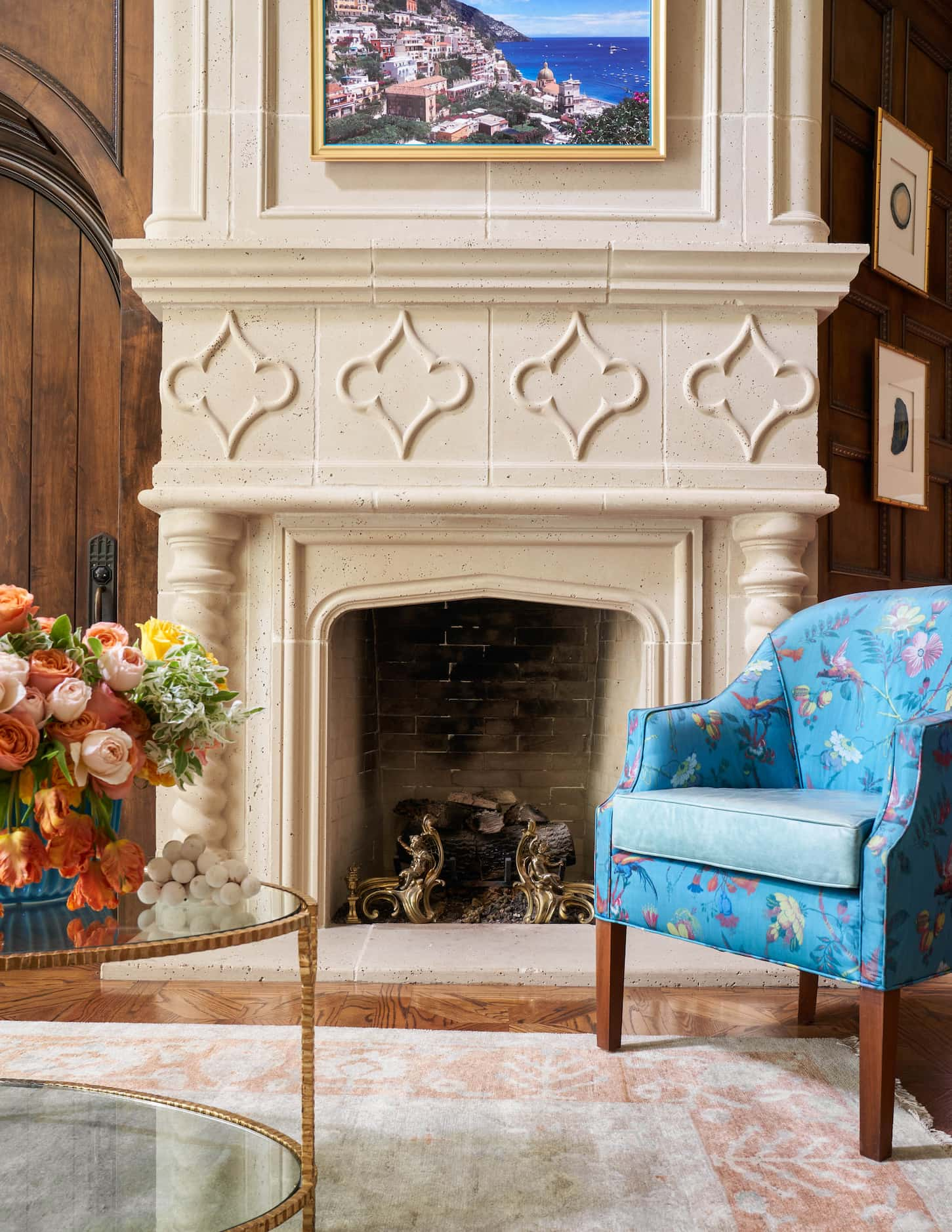 A bright blue chair sits in front of a large fireplace