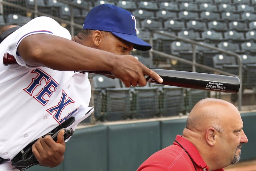 Texas third baseman Adrian Beltre tries to distract a video interview by tapping DMN...