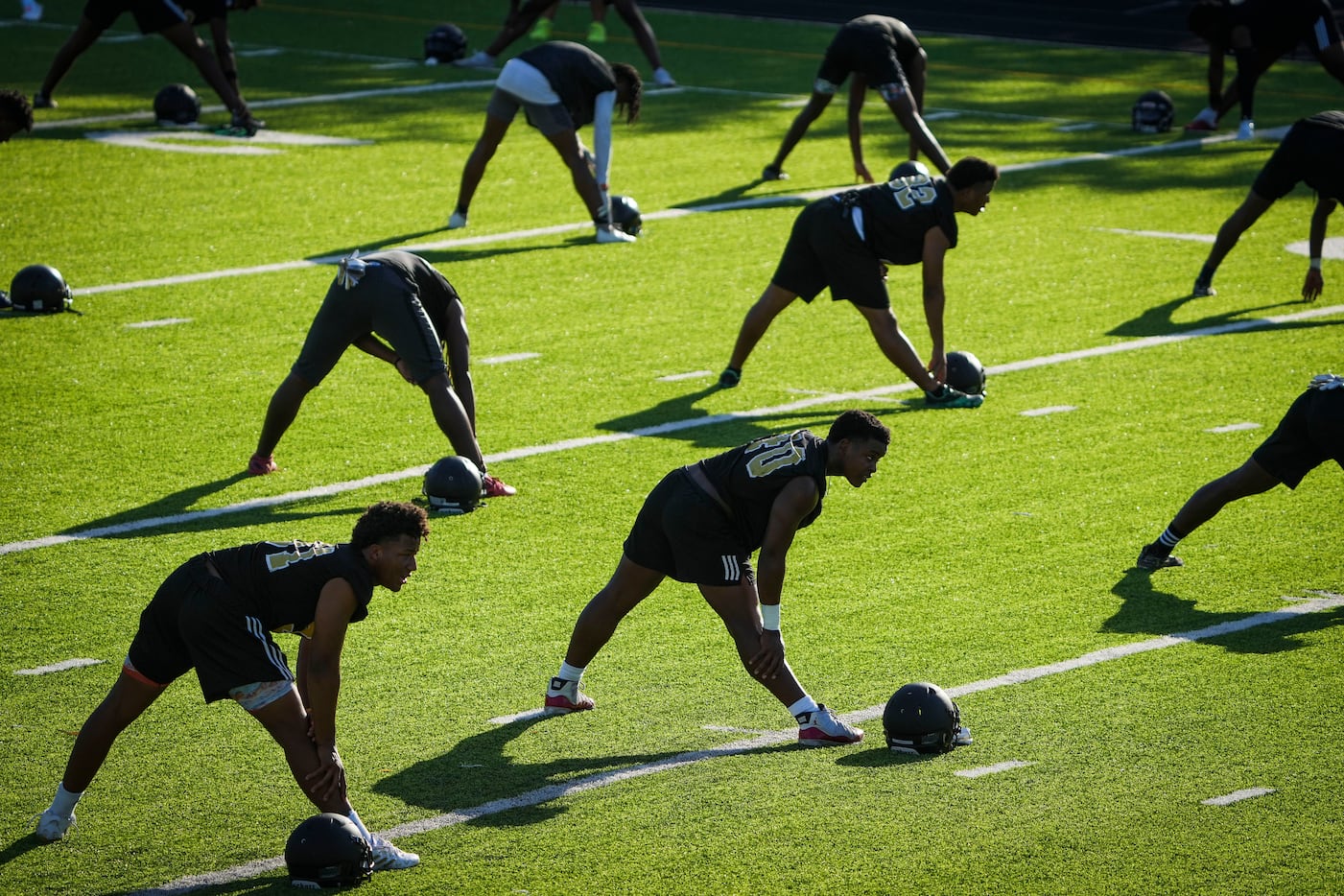 Players stretch during the first practice of the season for defending Class 5A Division II...