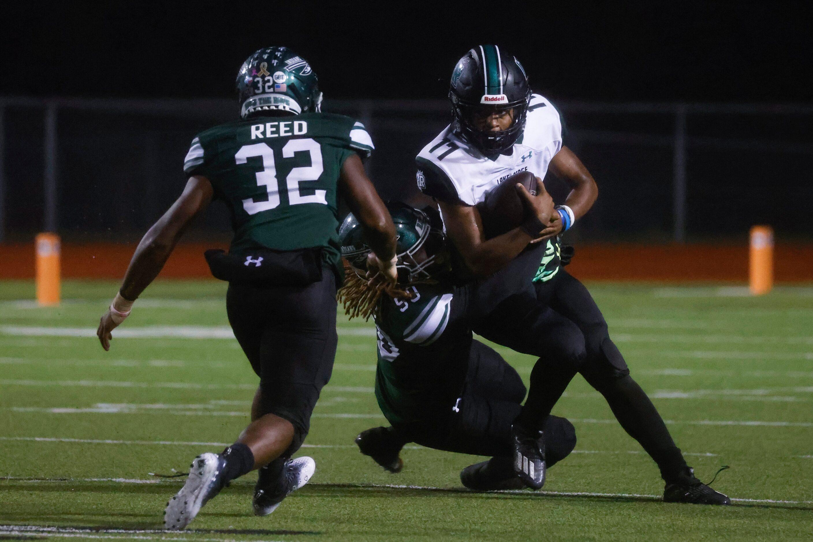 Waxahachie High School’s Rhyus Evans (50), left, sacks Mansfield Lake Ridge High School’s QB...