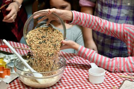 Megan Dempsey dumps birdseed into a bowl of gelatin, flour and water.