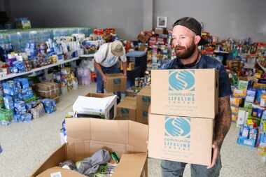 Volunteer Phillip Vogel moves donations out of the Valley View Community Center, on Monday,...