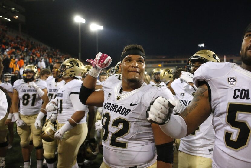 Colorado defensive tackle Jordan Carrell, center, joins teammates in celebrating after an...