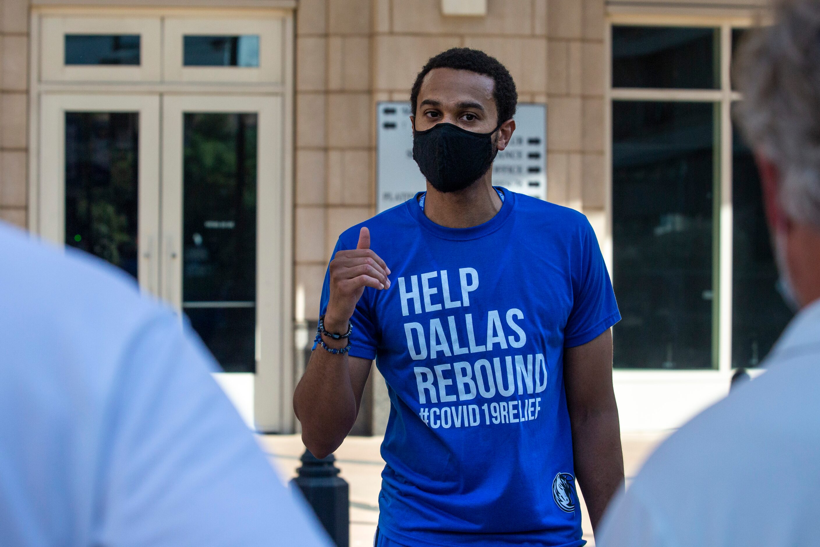 Dallas Mavericks General Counsel Sekou Lewis speaks with other members of a small group...