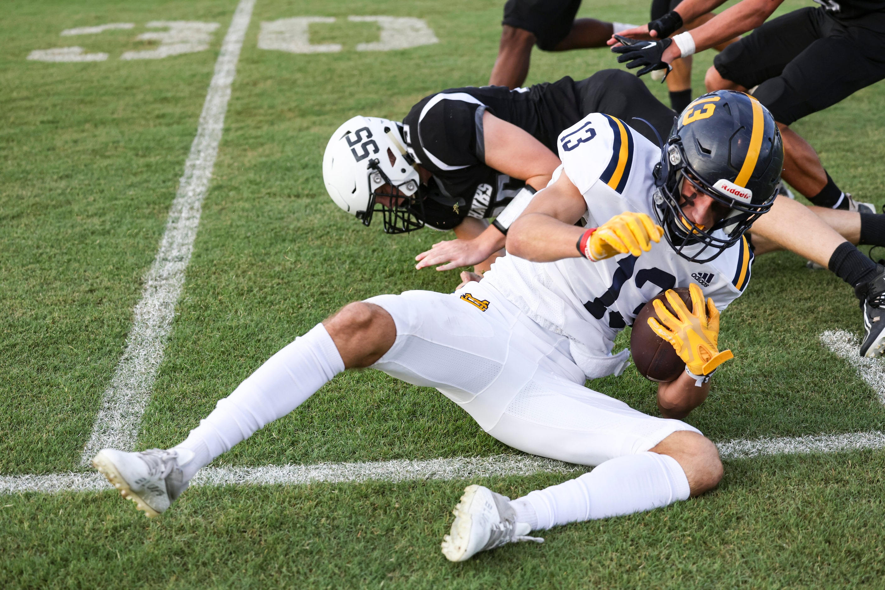 St. Mark's School of Texas Mateu Parker (13) falls just short of the 30 yard line while...