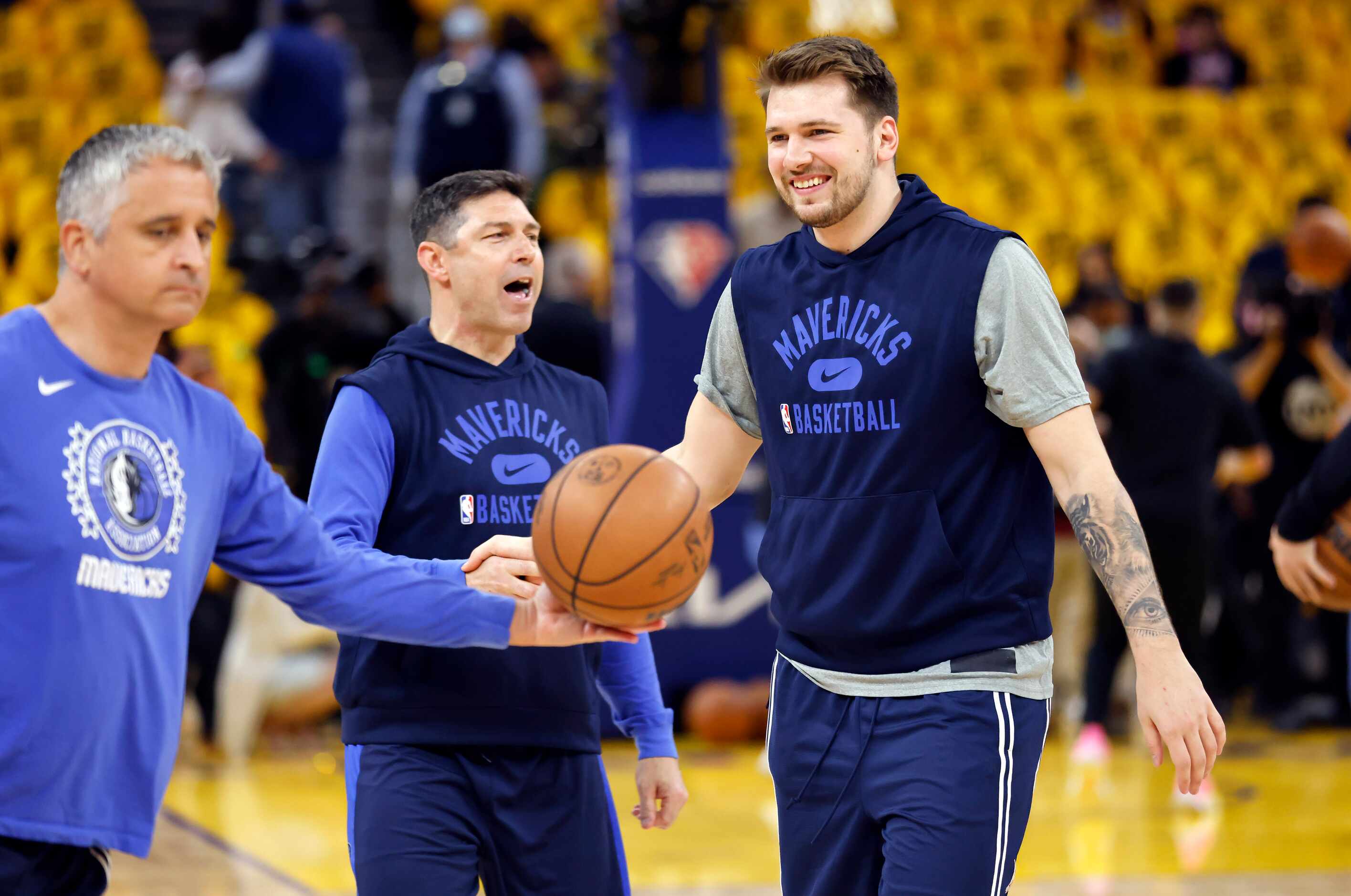Dallas Mavericks guard Luka Doncic laughs with shooting coach Peter Patton (center) after...