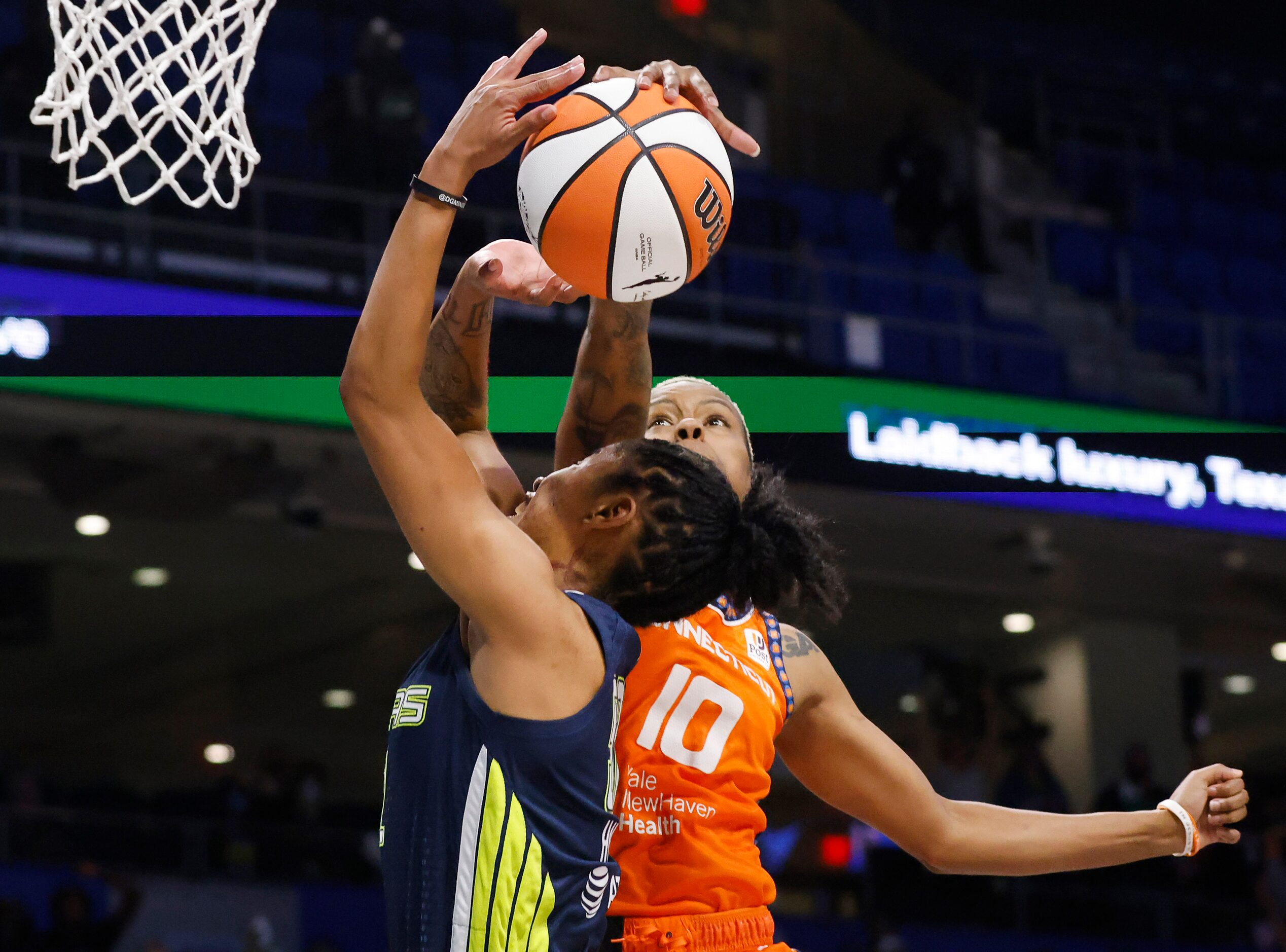 Connecticut Sun guard Courtney Williams (10) blocks a driving shot by Dallas Wings guard...