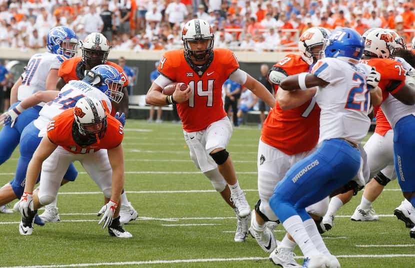 Oklahoma State quarterback Taylor Cornelius (14) carries during an NCAA college football...
