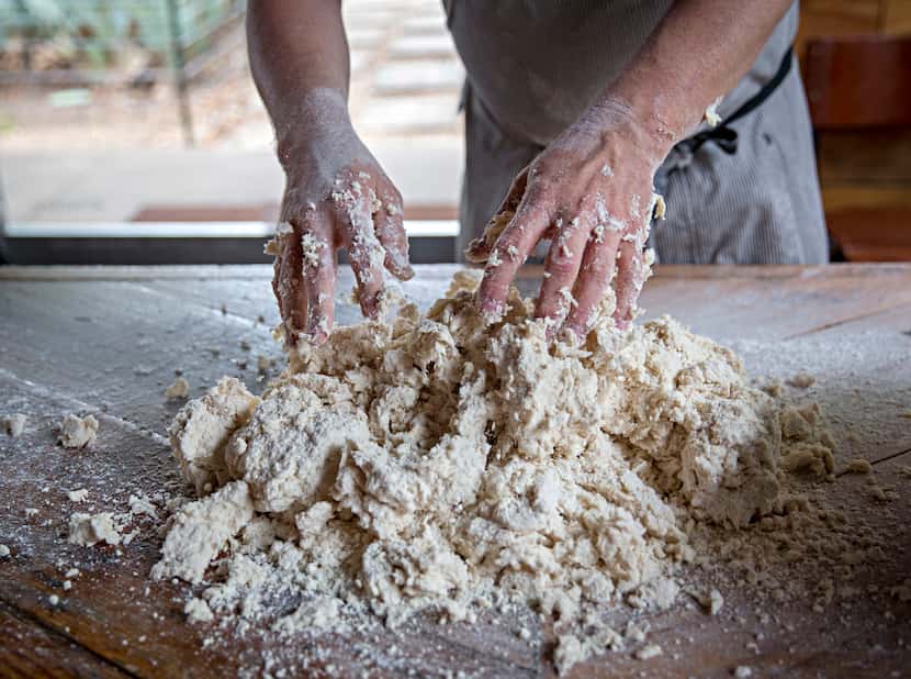 Chef Tim Byres dumps dough on a table as he makes buttermilk biscuits at Chicken Scratch...