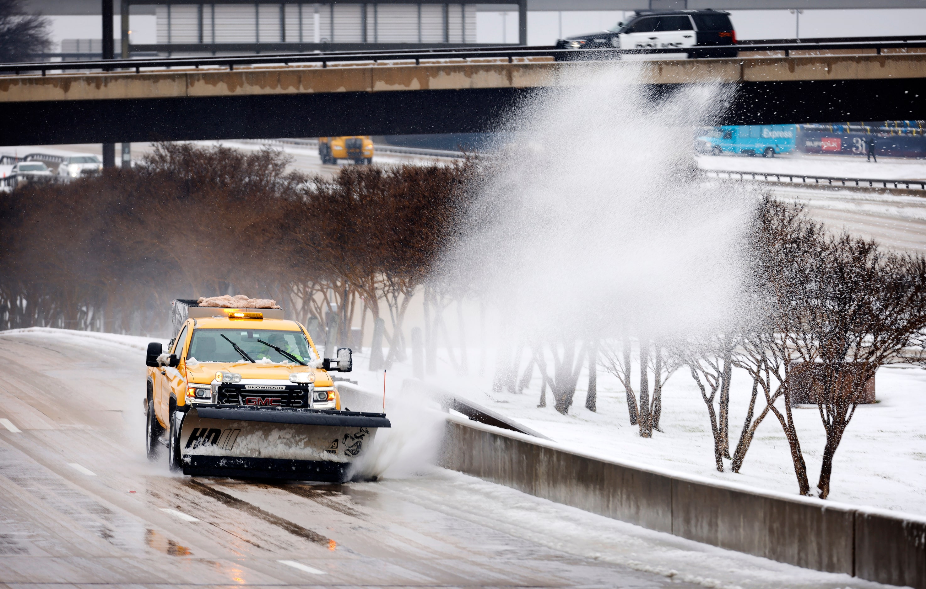 An airport truck clears sleet and slush from the service road at DFW Airport, January 9, 2025.