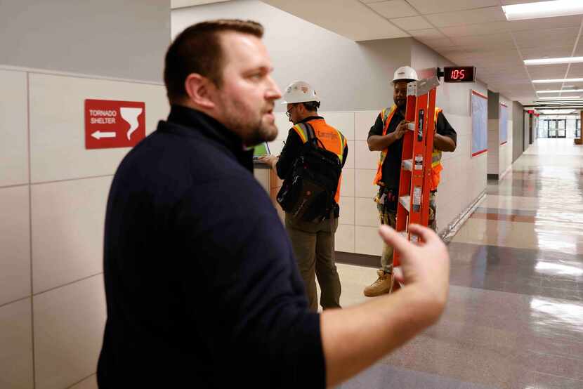 Construction workers are seen along the hallway as Thomas Jefferson High School Principal...