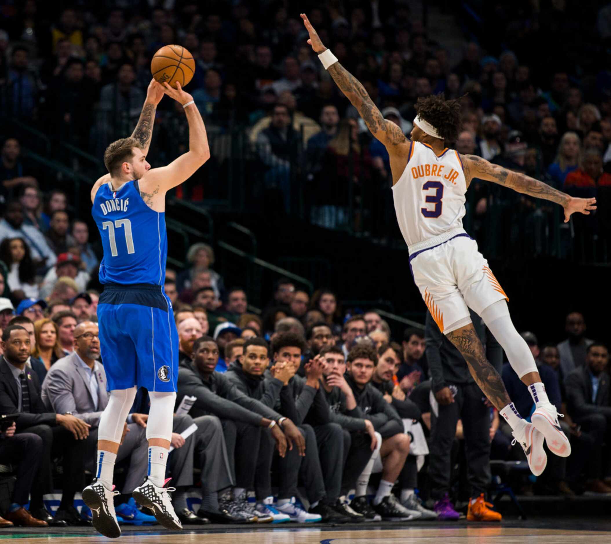 Dallas Mavericks guard Luka Doncic (77) takes a shot over Phoenix Suns forward Kelly Oubre...