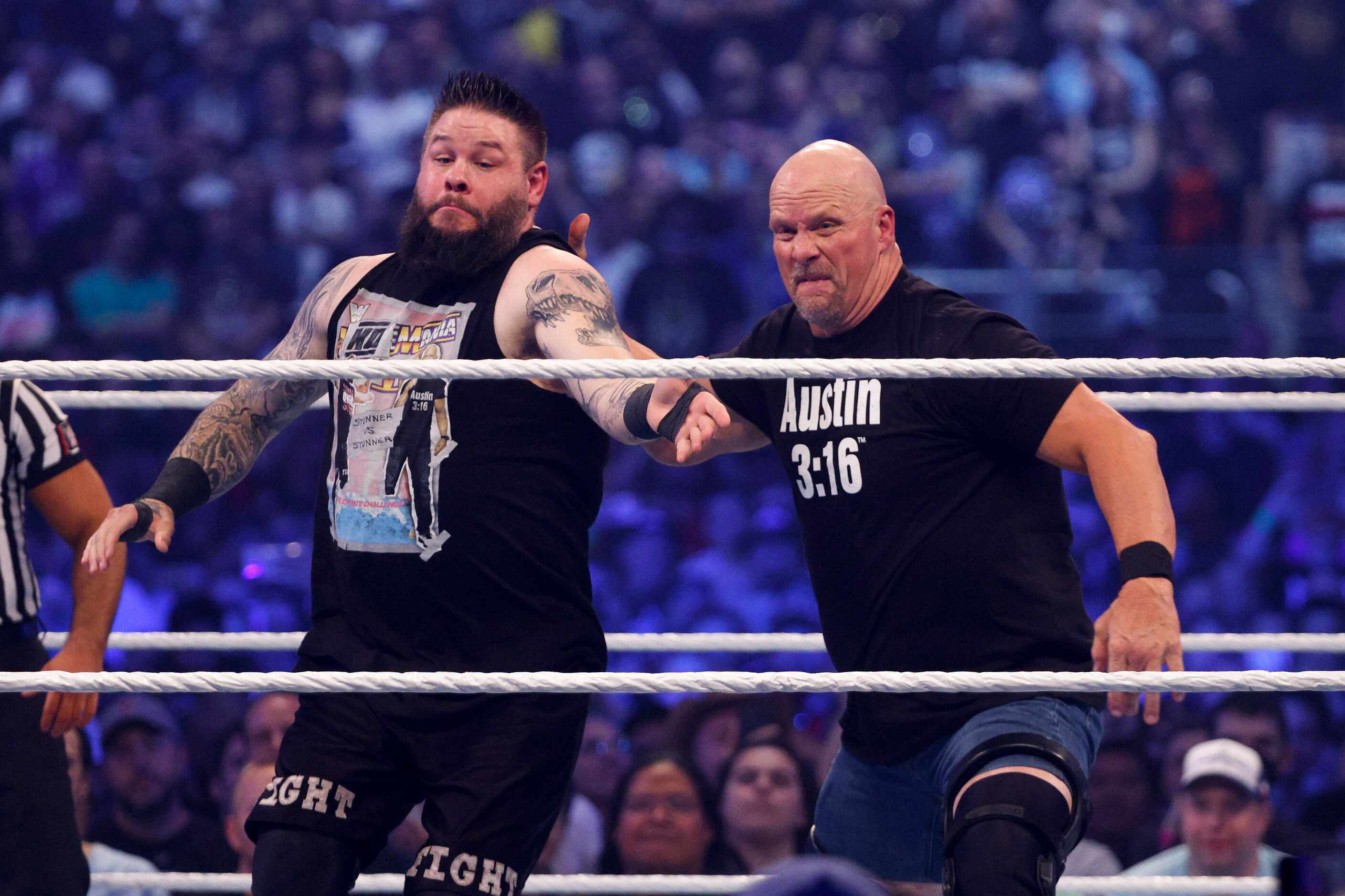 “Stone Cold” Steve Austin throws Kevin Owens into the ropes during a match at WrestleMania...