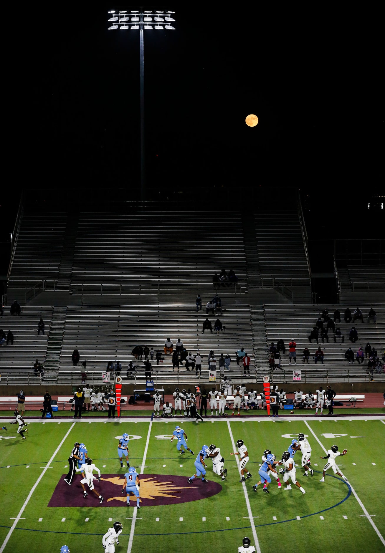 As the Harvest moon rises behind Loos Stadium, Pinkston quarterback Damareya Jones (7)...