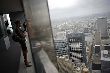 A woman looks at the Houston skyline from the city's Chase Tower Observation Deck in a photo...