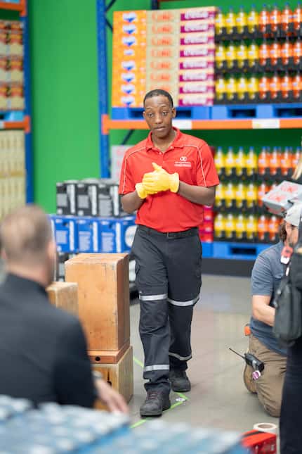 Arca Continental Coca-Cola Southwest Beverages employee in red polo shirt walks through...